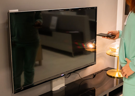 Mujer dejando en standby la televisión de su casa