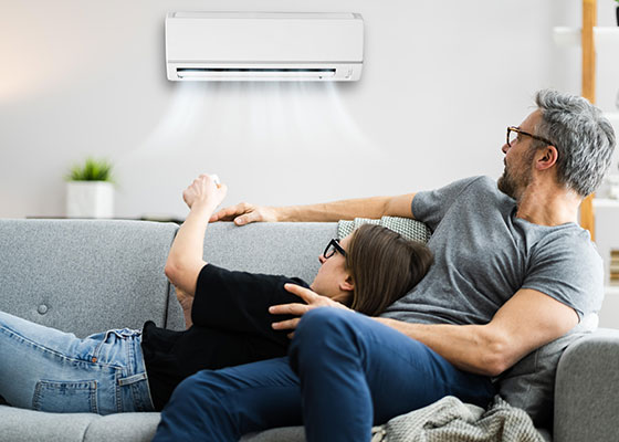 Pareja encendiendo el aire acondicionado