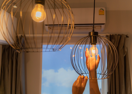 Persona cambiando bombillas en su hogar para reducir el consumo energético