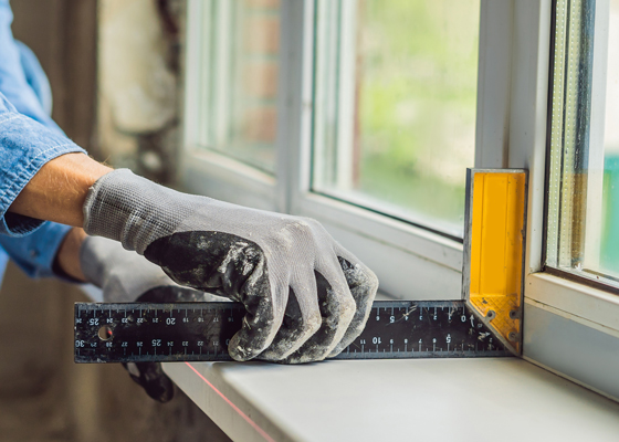 Chico revisando las ventanas de su casa para que no haya fugas en invierno